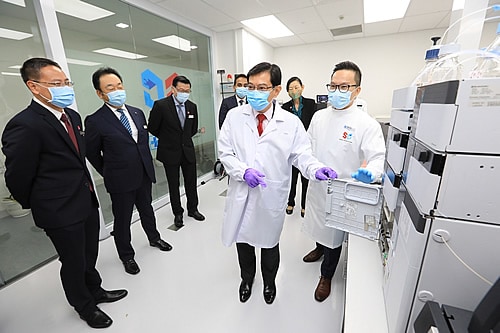 Deputy Prime Minister Heng views the mass spectrometer, which detects and measures multiple test compounds in a single sample with greater accuracy, at the Centre.