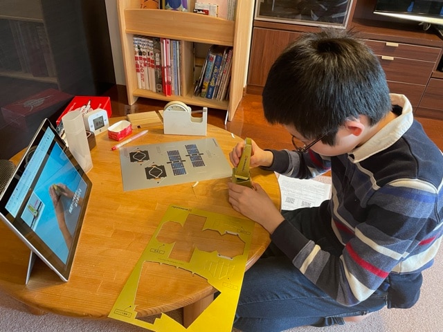 A Participant Assembling the Paper Craft