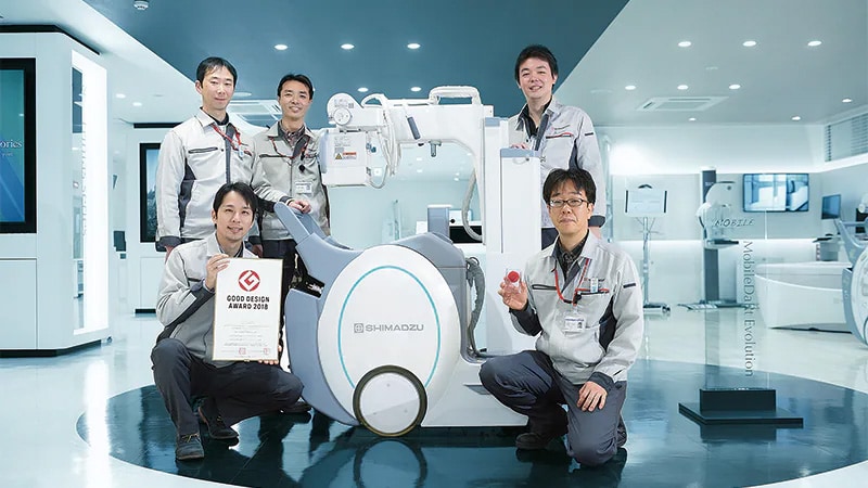 Members involved in the development of the MobileDaRt Evolution MX8 Version. From the bottom right, clockwise: Masaaki Shibata, Assistant Manager of Global Marketing Department, Medical Systems Division; Tomoya Sugie, Assistant Manager of Product Design Unit, Corporate Product Design Center; Tsuyoshi Takayanagi, Manager of R&D Department, Medical Systems Division; Tadahiko Nakahara, Manager, and Toru Hayakawa, Assistant Manager of R&D Department, Medical Systems Division