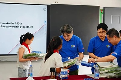 SSL employees handing out knapsacks, pencil cases, stationery, and other school supplies to the children