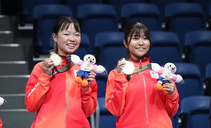 Holding the doubles gold medal. Right: Rina Komokata; left: her partner Riko Suzuki (NTT Urban Development)