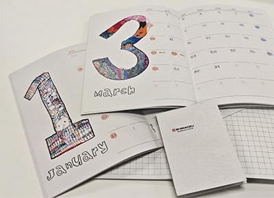 Notebook and memo pad featuring employee artwork