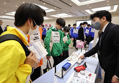 A Shimadzu Rika employee demonstrating the “Smart Cart” mechanics experiment kit at the corporate exhibition booth