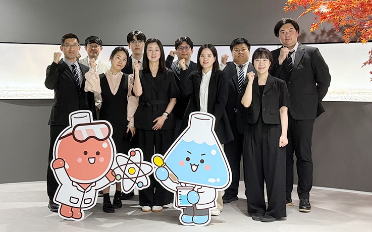 Members of the SSK’s Technical Research Center.. Lee is in the center of the front row. Together with SSK's original characters, Peri & Tube
